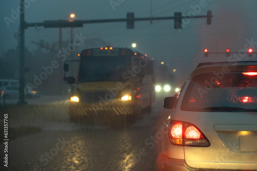Cars waiting at traffic light at night during rain falling on american wide multilane street intersection. Transportation system in USA © bilanol