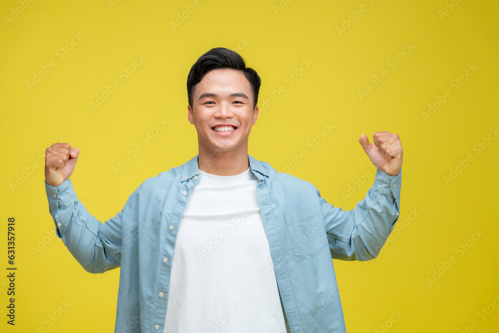 Young man very happy and excited doing winner gesture with arms raised,