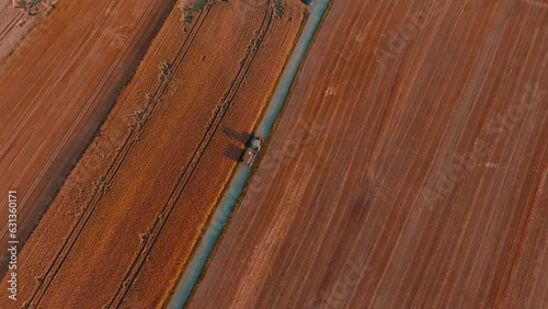 Agricultural tractor going to work in the field or from the field seen from the drone, aerial view. The concept of farming, agricultural landscapes.