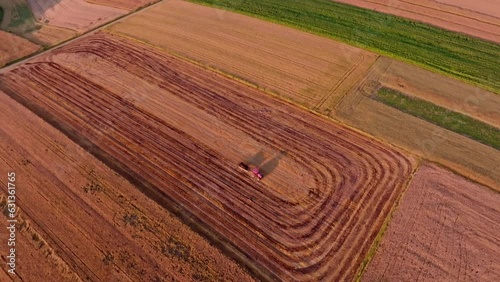 Agricultural tractor working in a farmland seen from a drone, aerial view. The concept of farming, agricultural landscapes.