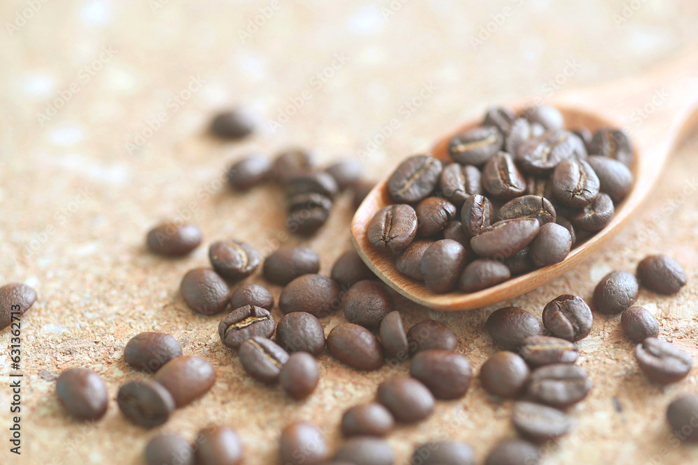 Roasted coffee bean with wooden coffee spoon on cork board, Close-up coffee beans Roasted coffee bean with wooden coffee spoon on cork board, Close-up coffee beans