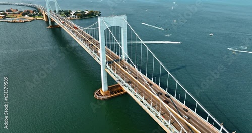 Cars going to and from the Bronx, New York. Aerial view of the Throgs Neck Bridge on sunny day. Boats sailing on the East River at backdrop. photo