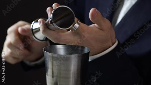Bartender pouring vodka into a boston shaker