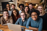 A diverse team of happy modern office workers having fun at work Fun multiethnic group of people in t-shirts and jeans with laptops and notebooks sitting in the office and laughing