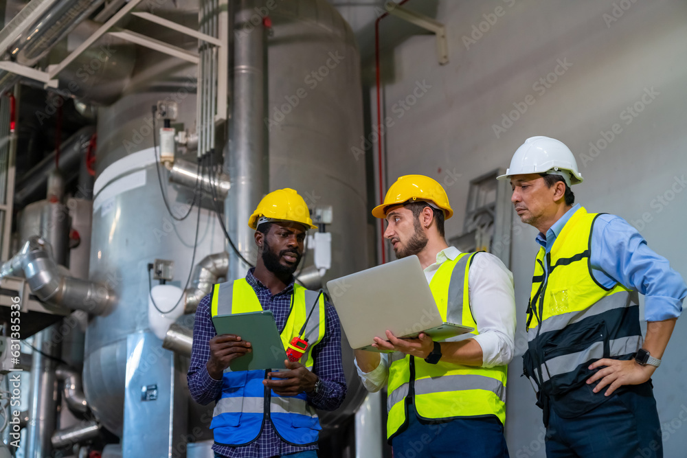Group of Diversity electrical engineer in safety uniform working together at factory site control room. Industrial technician worker maintenance and checking power system at manufacturing plant room. Group of Diversity electrical engineer in safety uniform working together at factory site control room. Industrial technician worker maintenance and checking power system at manufacturing plant room.
