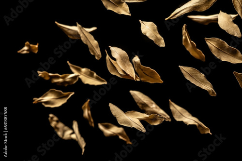 Close-up of dried bay leaves flying in air against black background