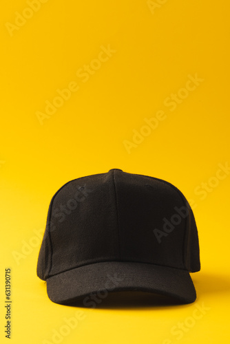 Black baseball cap and copy space on yellow background