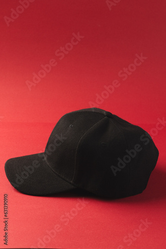 Black baseball cap and copy space on red background