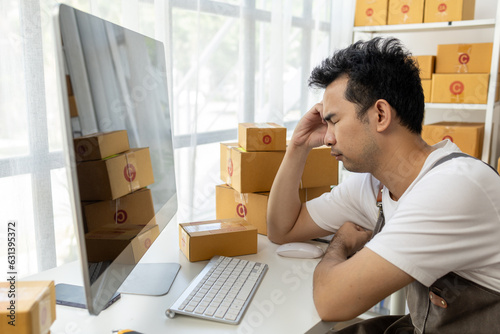 Male online store owner, he is stressed because there are no orders, online store owner distributes products on website, packs orders and delivers them by private courier. Online shopping concept.