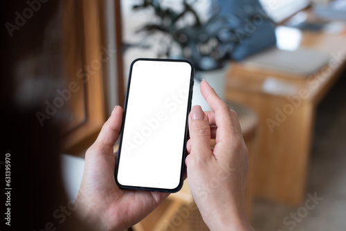 Mockup, woman\'s hand holding using mobile phone at coffee shop with copy space, white blank screen for text, mobile app design and advertising, online marketing