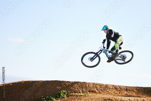 Cycling, sports and man jump with bicycle for adrenaline on adventure, freedom and in air for speed. Mountain bike, tricks and cyclist for training, exercise and fitness on dirt road, trail and track photo
