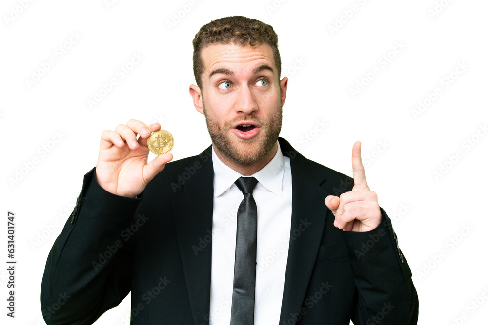 Young business blonde man holding a Bitcoin over isolated chroma key background thinking an idea pointing the finger up Young business blonde man holding a Bitcoin over isolated chroma key background thinking an idea pointing the finger up