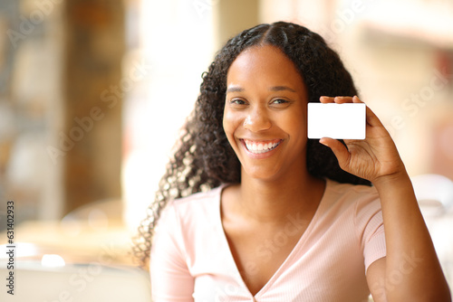 Fotografie, Tablou Black woman showing blank credit card in a bar