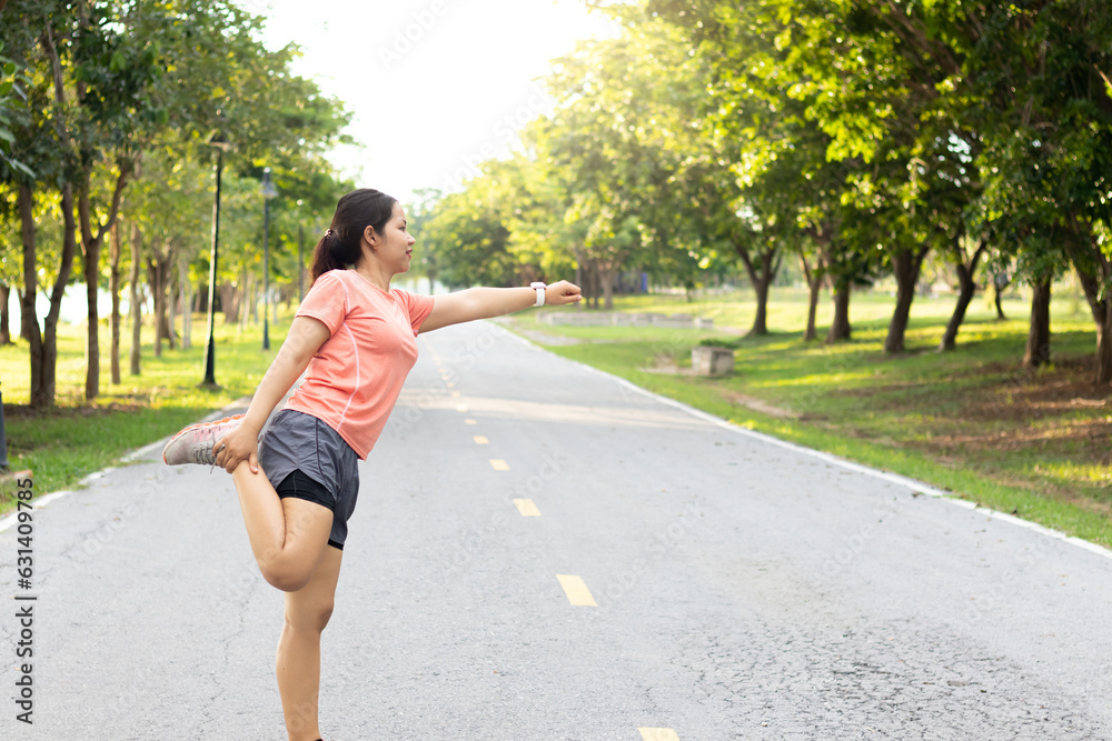 Young Asian woman workout before fitness training session at the park. She is stretching her arms and looking away at the park. Healthy girls warming up outdoors. Young Asian woman workout before fitness training session at the park. She is stretching her arms and looking away at the park. Healthy girls warming up outdoors.