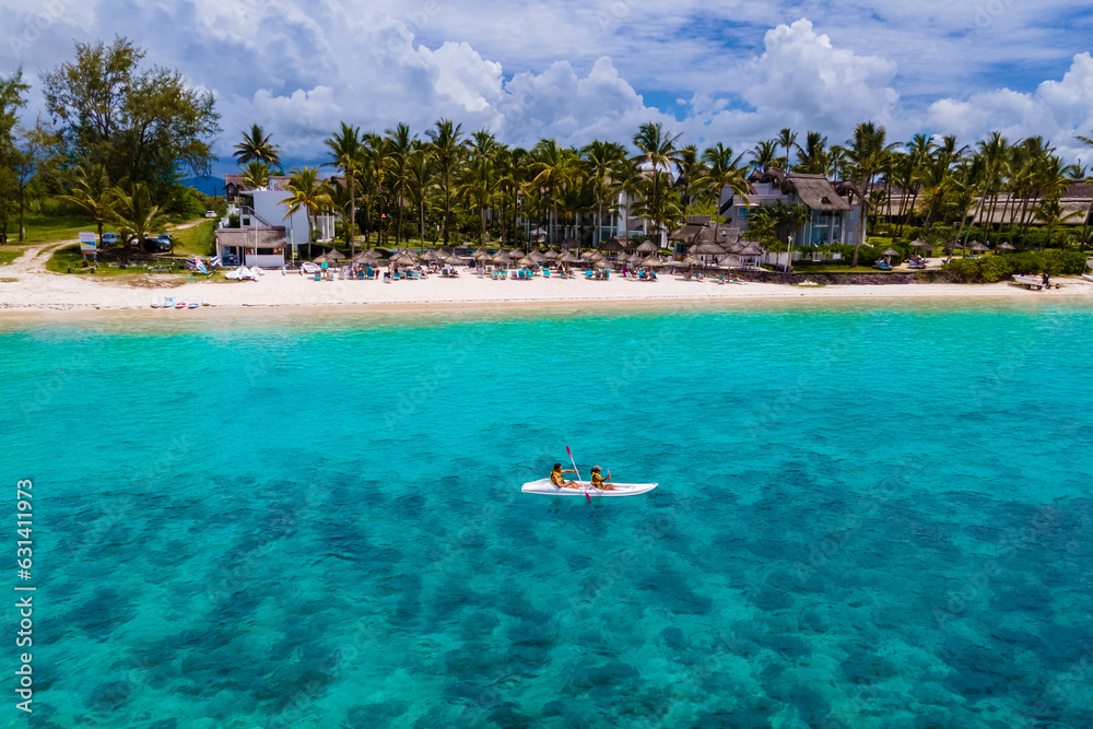 Mauritius vacation, couple man and woman in a kayak in a blue ocean in Mauritius. men and women peddling in a turqouse colored ocean of the Island of Mauritius Mauritius vacation, couple man and woman in a kayak in a blue ocean in Mauritius. men and women peddling in a turqouse colored ocean of the Island of Mauritius