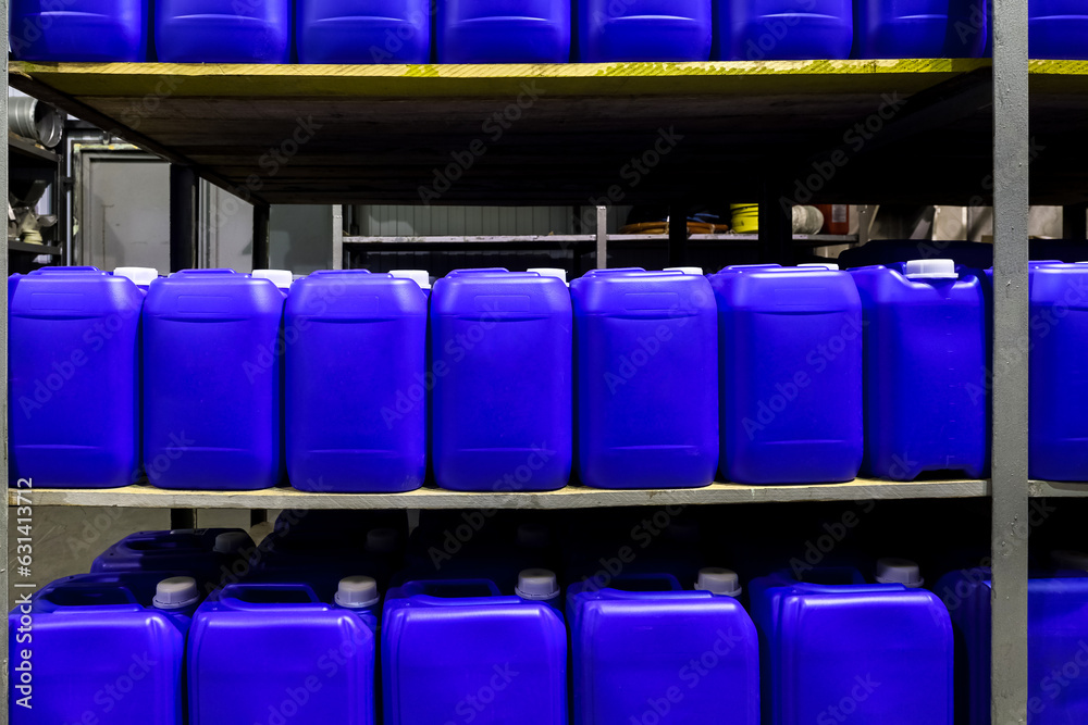 Rows liquid containers stands on rack in warehouse storage of chemical