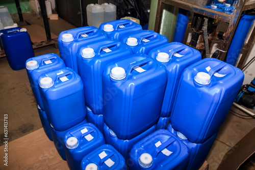 Top view of some liquid containers standing on floor in warehouse storage of chemical liquids. Background of storage cans in warehouse. Concept of warehousing and stored of goods. Copy ad text space