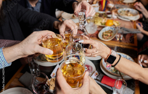 Clinking glasses with alcohol and toasting, party.