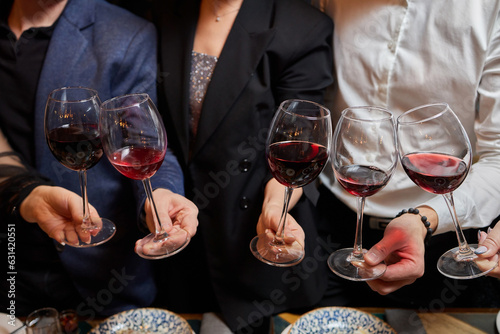 Clinking glasses with alcohol and toasting, party.