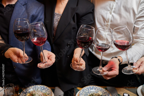 Clinking glasses with alcohol and toasting, party.