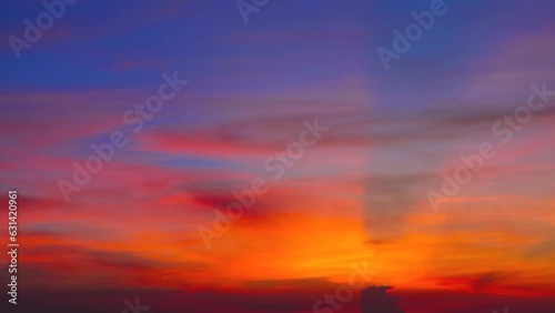 Colorful sunset blue red orange yellow sky with dark orange cloud and ray on right frame