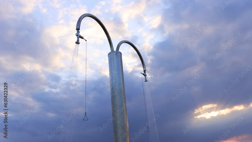 Shower on sea beach off season time in overcast weather. Fresh water flowing from both sides in middle of coast at sunrise. Arrangement of beach for tourists' recreation. Shower on sea beach off season time in overcast weather. Fresh water flowing from both sides in middle of coast at sunrise. Arrangement of beach for tourists' recreation.