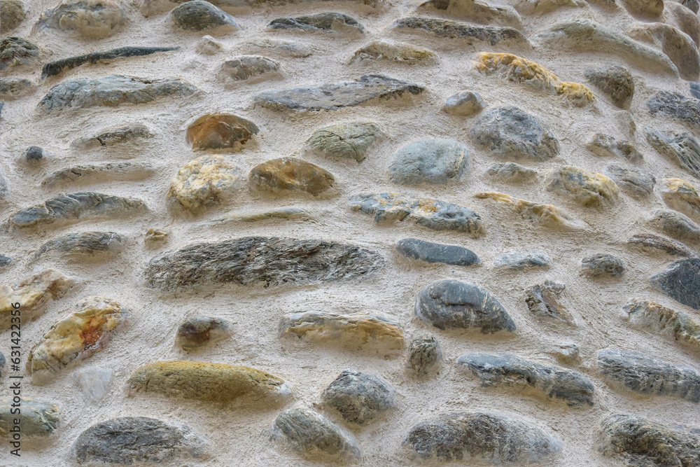 Background of old stone wall, full frame. Texture of aged building surface. Detailed unusual backdrop, abstract design. Hand laying. Close-up. Selective focus. Background of old stone wall, full frame. Texture of aged building surface. Detailed unusual backdrop, abstract design. Hand laying. Close-up. Selective focus.