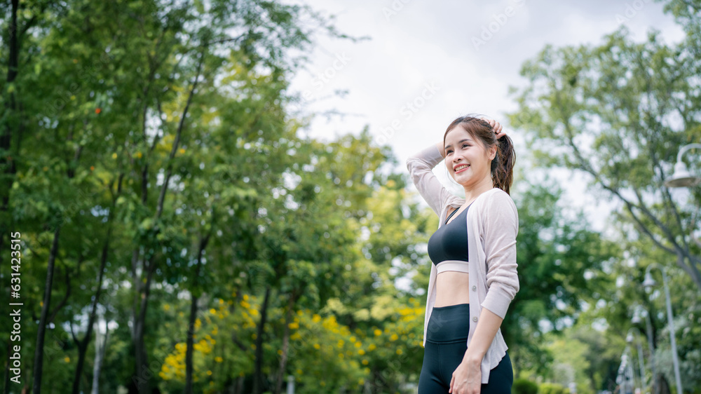 Portrait of young woman in fitness wear exercising in park. Healthy Concept, copy space.