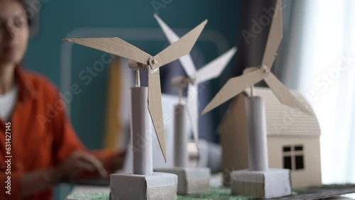 Woman working on project with windmills sitting in home office using laptop to enter data