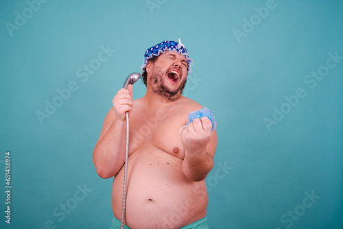 Funny fat man is washing himself in the shower.