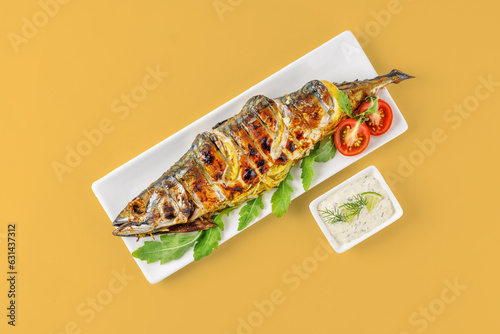 grilled mackerel with lemon and tomatoes on a yellow background for the menu, studio shooting