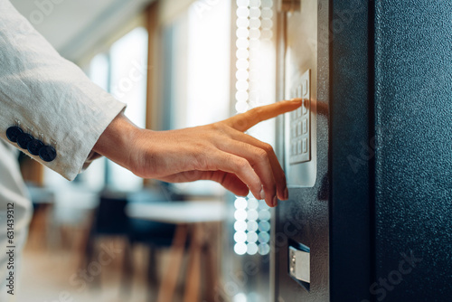 Close up view of woman's finger pushing number button on keyboard of snack vending machine. Self-used technology and consumption concept