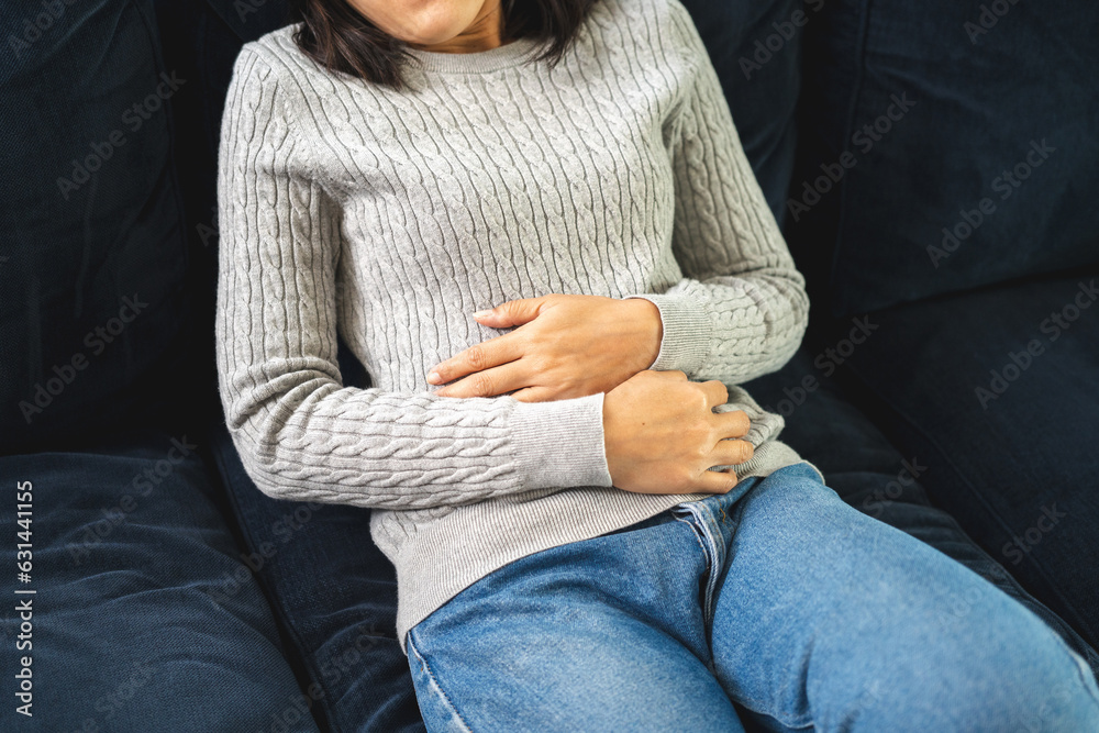 Woman had a stomach ache menstrual pain and gastritis inflammatory bowel disease. She put hand on his stomach and squeezed it to relax and soothe has go to toilet need to poop - obrazy, fototapety, plakaty 