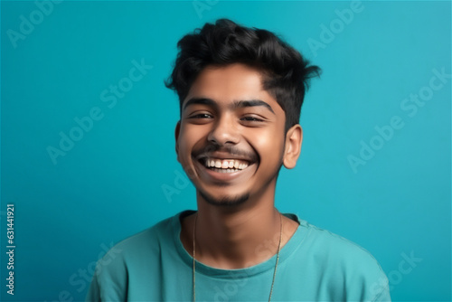  Indian young adult man smiling on a blue background