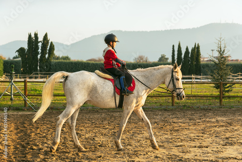 Little Boy Riding A White Horse. Horseback Riding. Dressage horse in training, front view. Dressage horse in the arena. © 22Imagesstudio