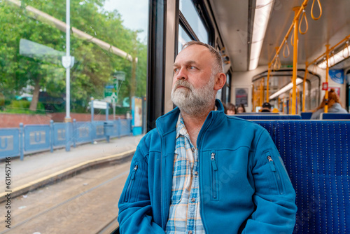 portrait of a dreamy bearded man in a blue jacket on a bus. Lifestyle concept