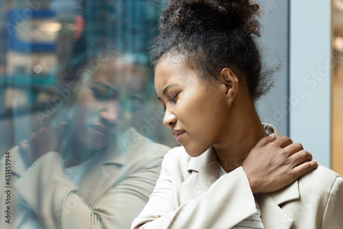 African office worker woman having shoulder sickness or neck pain from overwork or office syndrome