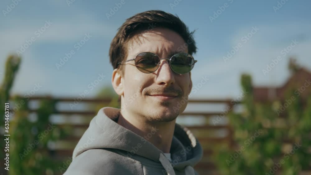 Cheerful handsome guy with sunglasses enjoying the sun and fresh air Cheerful handsome guy with sunglasses enjoying the sun and fresh air