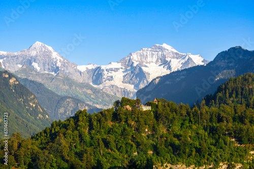 Idyllic landscape in the Alps with snow-capped mountain tops in the background.