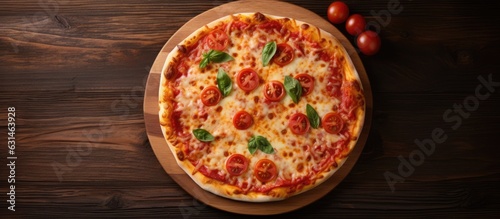 A Pizza Margherita placed on a wooden surface with empty space around it. is taken from the