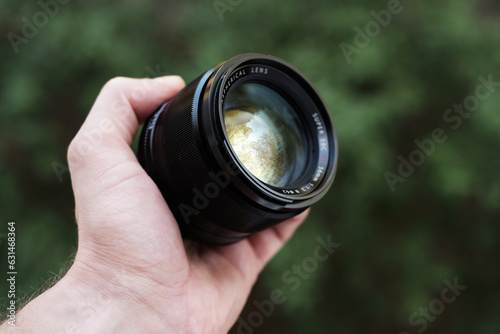 Konstfotografi Man holding camera lens in hand