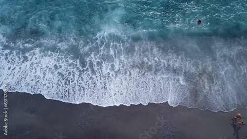 Ripresa aerea del mare e la spiaggia - Vista dall'alto delle onde del mare che si infrangono contro il bagnasciuga della spiaggia durante il mare in tempesta - Mare mosso photo