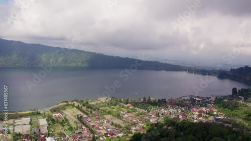 Bird's Eye View of Bali Village, Lake, and Cloud-Capped Mountains - 4K Drone Footage of Scenic Rural Landscape and Wilderness