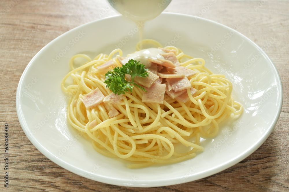 steamed spaghetti white cabonara cream sauce topping slice ham pork on plate 
