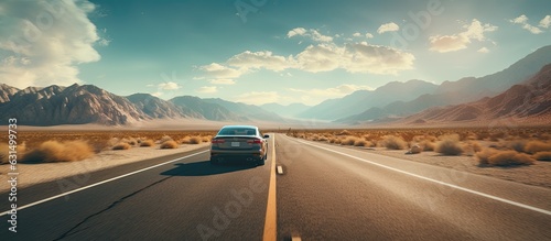 A vehicle embarks on a road trip adventure through a desert on a hot summer morning. It drives