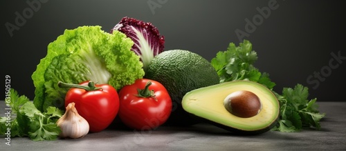 lettuce, tomato, parsley, avocado, and onion placed on a gray background. It represents vegetarian