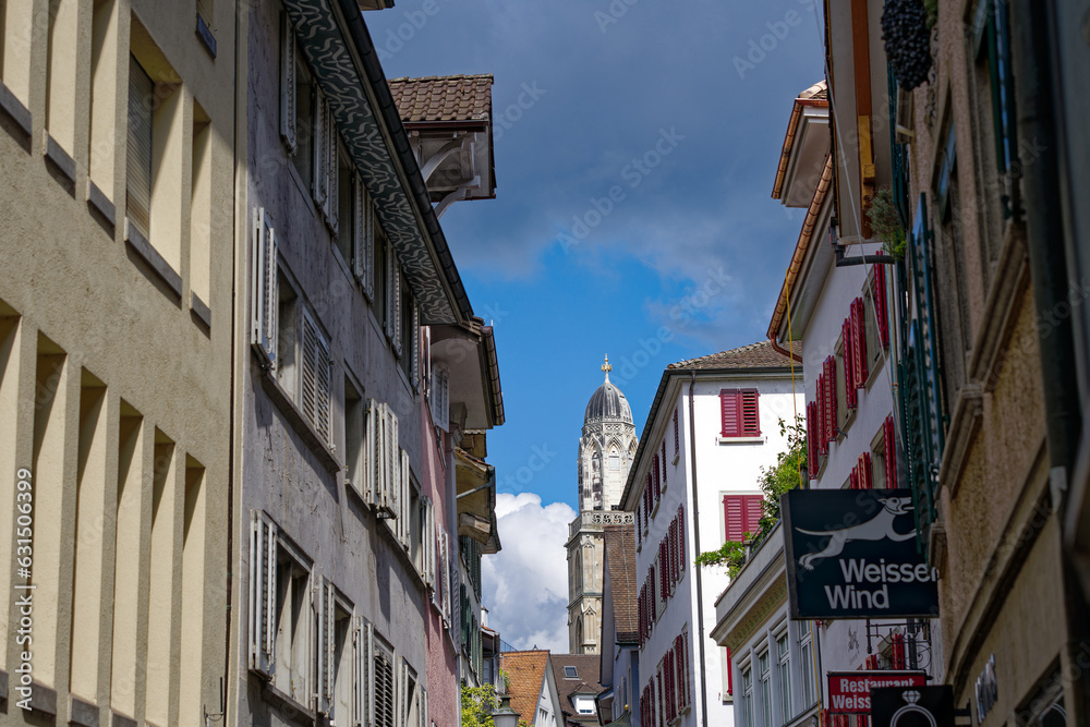 Alley at the old town of City of Zürich with church tower of Great Minster church in the background on a sunny summer noon. Photo taken August 5th, 2023, Zurich, Switzerland. Alley at the old town of City of Zürich with church tower of Great Minster church in the background on a sunny summer noon. Photo taken August 5th, 2023, Zurich, Switzerland.