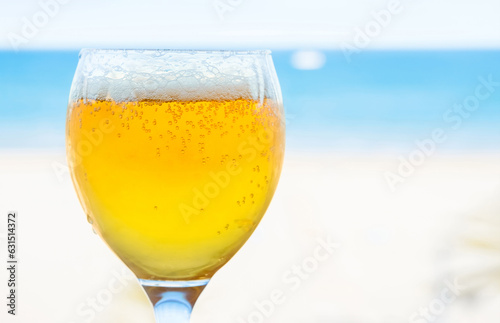 Glass of beer on a blurred blue background of a sea. Copy space. Shallow depth of field