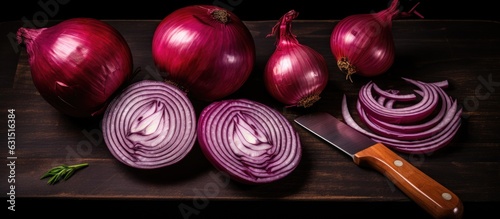 A photograph of red onions, both whole and sliced, along with a knife, set against a black background.