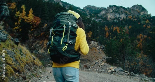Female backpacker on mountain path adventure on autumn season